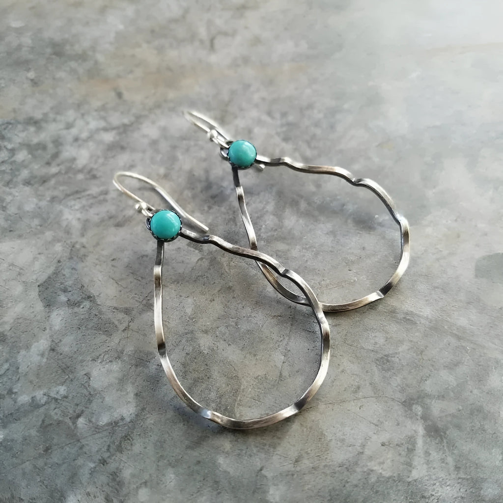 A pair of vintage-style bohemian earrings with turquoise circles and geometric shapes in antique silver alloy.