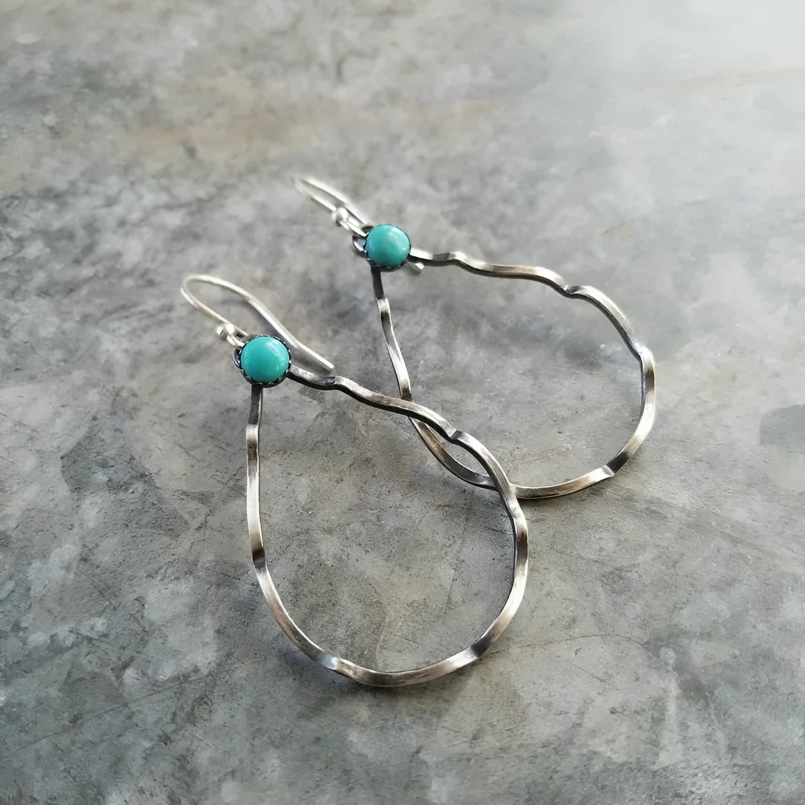 A pair of vintage-style bohemian earrings with turquoise circles and geometric shapes in antique silver alloy.