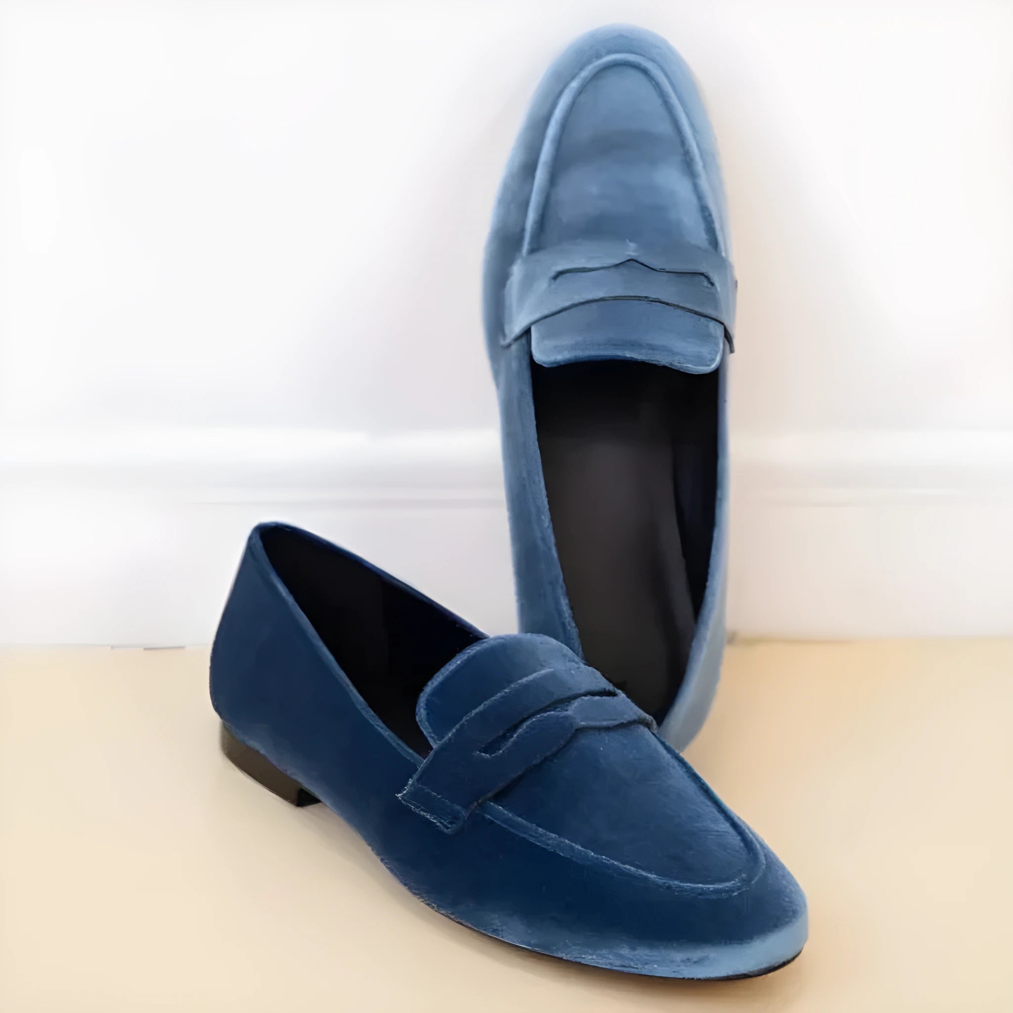 Blue and black low-top casual loafers with a round toe and rubber sole.