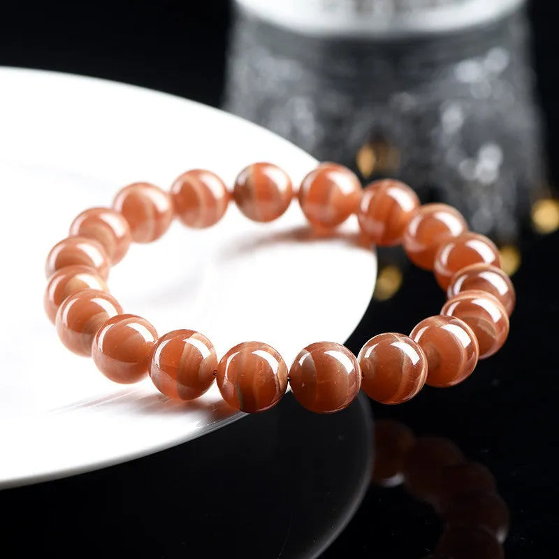 Natural Old Mine Rhodochrosite round bead bracelet with Ruyi element, shown in 6mm and 8mm sizes.
