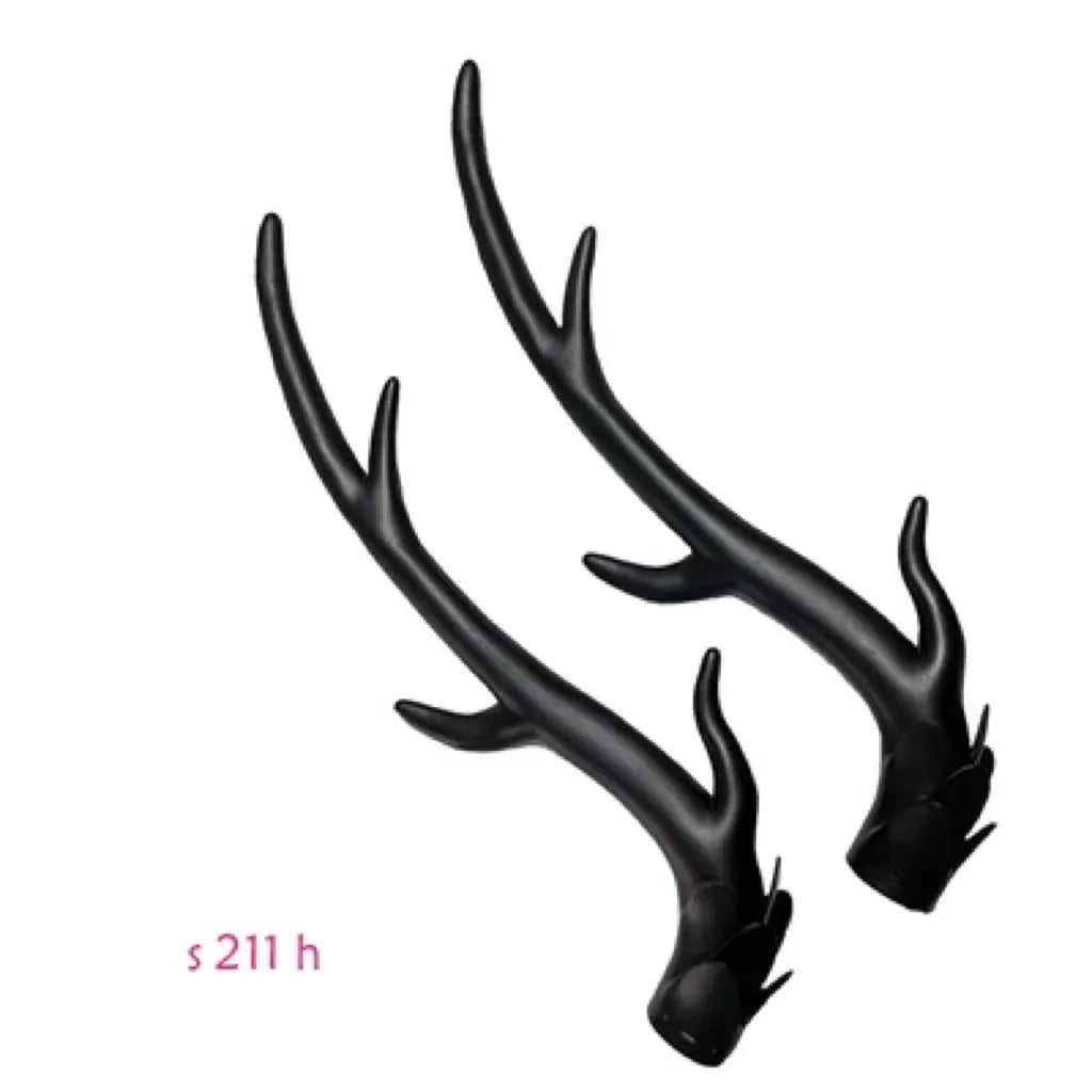 Pair of black resin dragon horn decorations next to a motorcycle helmet, showing scale and detailed texture.