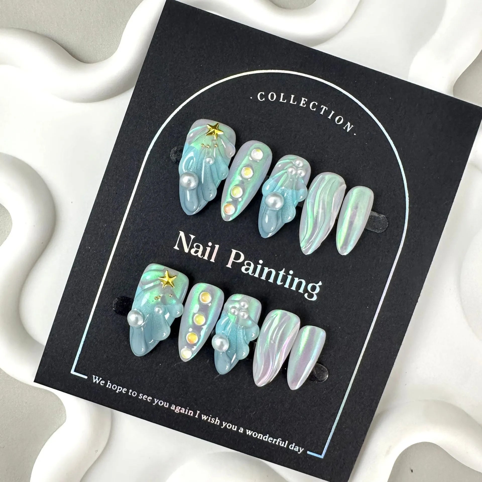 Set of blue plastic shell-shaped nail stickers in sizes XS, S, M, and L