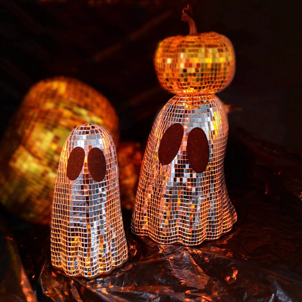 Silver glass Halloween ghost decoration with mosaic mirror patch design on a desktop.