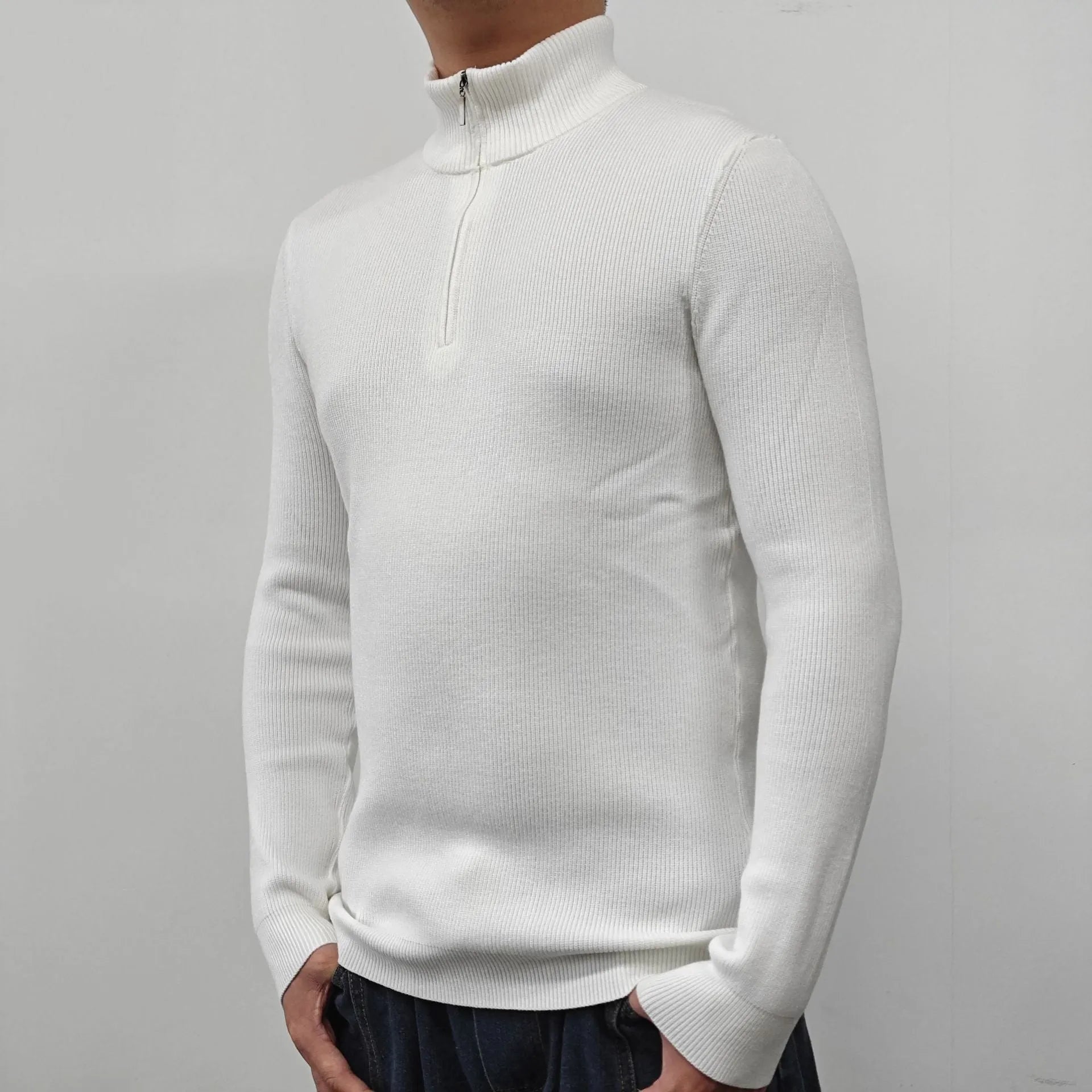 Man wearing a grey zip-front half-turtleneck sweater, a casual long-sleeve pullover.