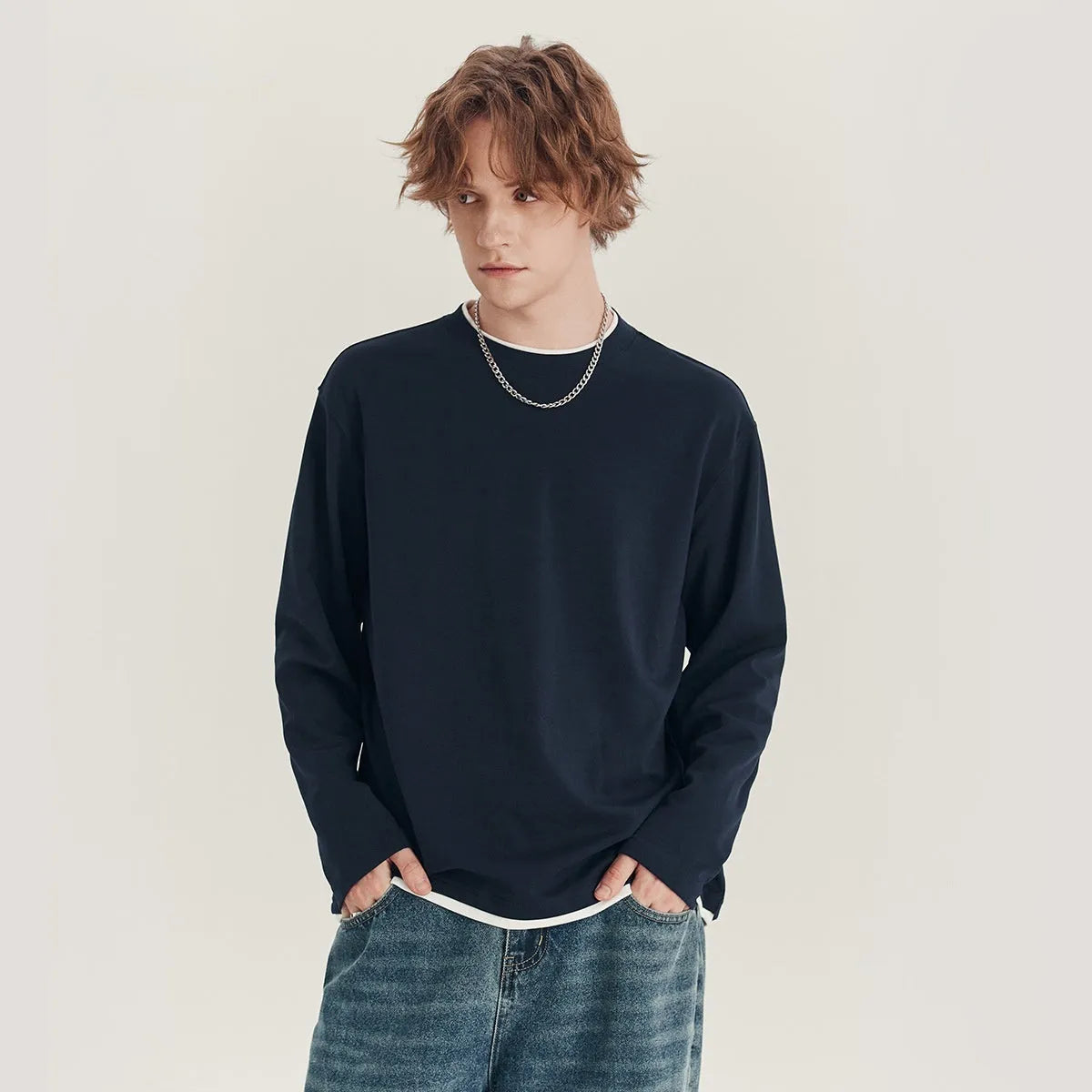 Man wearing a loose grey long-sleeved cotton blend T-shirt with a round neck.
