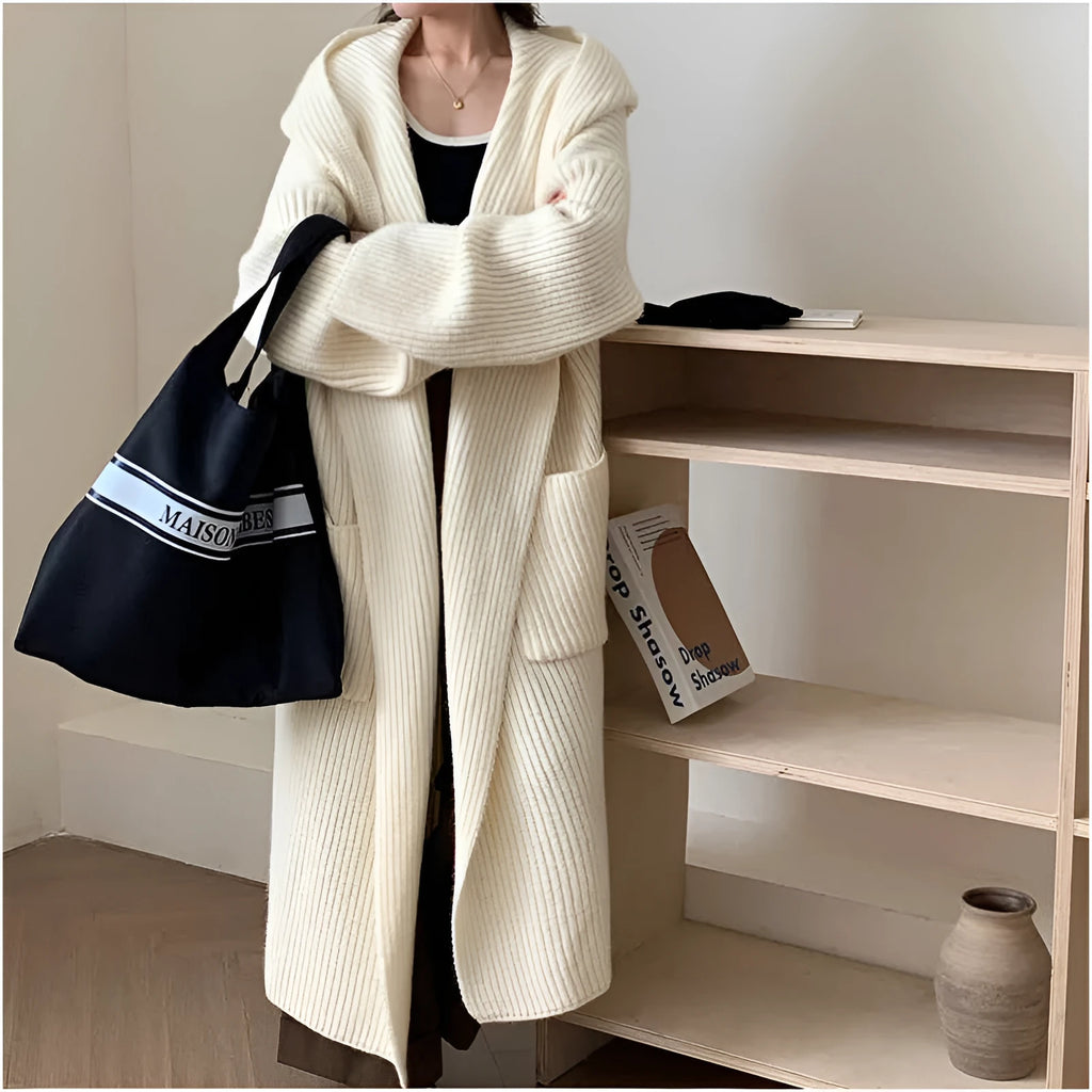 A woman wearing a loose, milky white hooded cardigan coat with raglan sleeves.