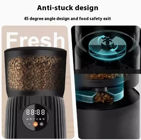 Black automatic pet feeder with digital timer display and remote control on a table.