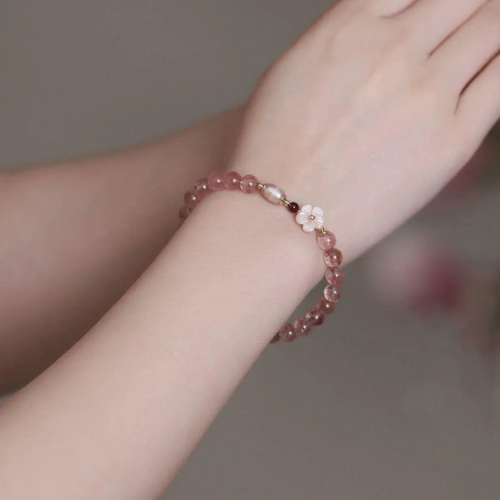 Women's strawberry quartz crystal flower bracelet showing peach blossom charm bead detail