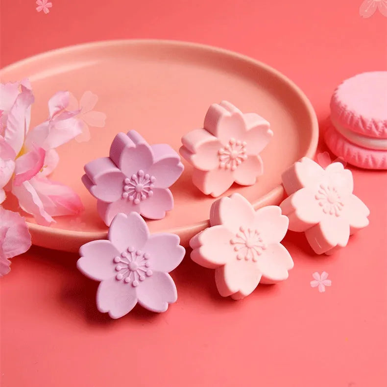 Assortment of cherry blossom decorated erasers in various colours from a bulk pack.