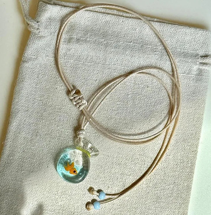 Women's necklace with coloured glaze skirt joker pendant on a beige cotton and linen chain, 45cm long.