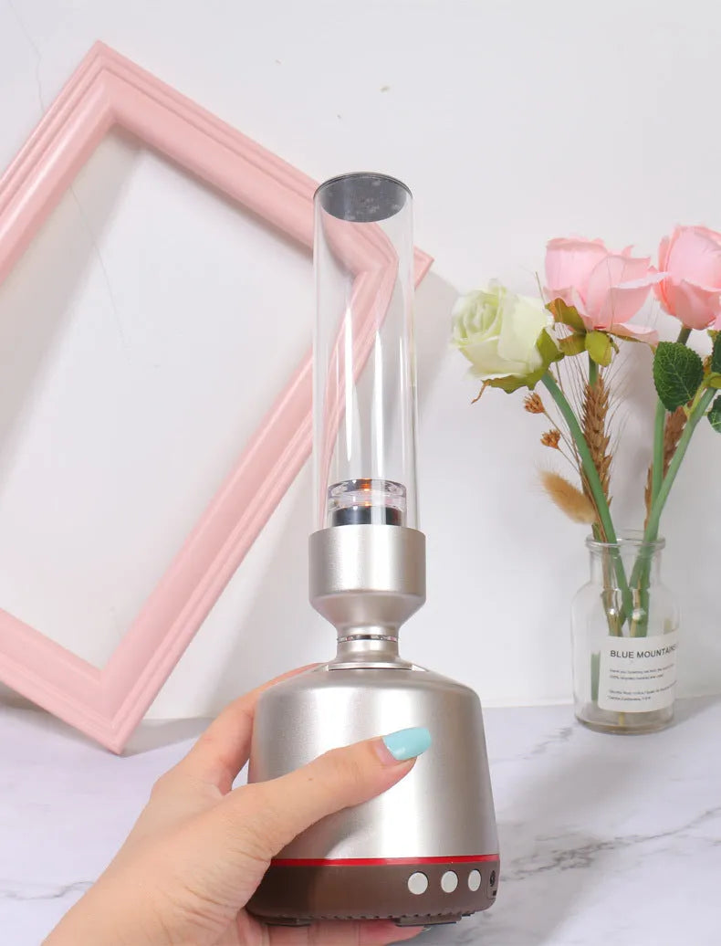 White silver cylindrical Bluetooth speaker with night light function on a table.