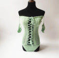 Off-shoulder one-piece swimsuit in polyester fabric on a mannequin.