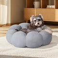 White fluffy flower-shaped pet bed with raised teddy fleece edges and round donut design on a light floor
