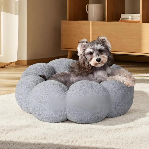 White fluffy flower-shaped pet bed with raised teddy fleece edges and round donut design on a light floor