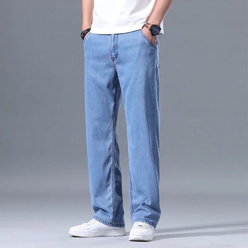 Man wearing light blue loose-fit straight-leg lyocell jeans with a zip fly
