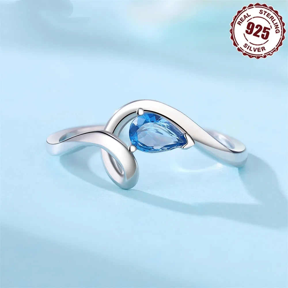S925 sterling silver open-end ring with curve inlaid blue zircon stone and fold design on a white background