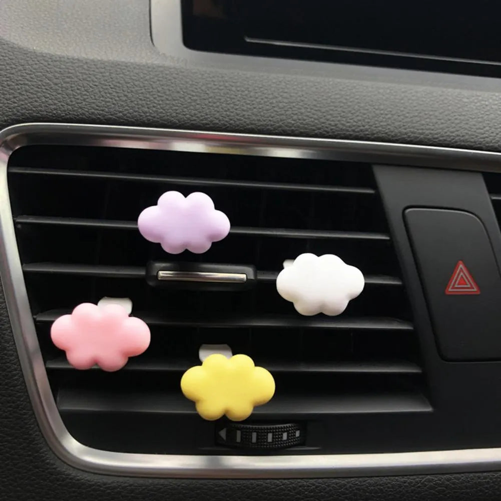 Resin cartoon car fragrance clip in pastel colours on a car air vent.