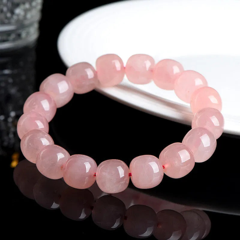 Close-up of a pink natural crystal bracelet with polished barrel-shaped beads measuring 8-10mm.