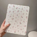 Transparent tri-fold Apple iPad case with cartoon floral print showing magnetic stand function.