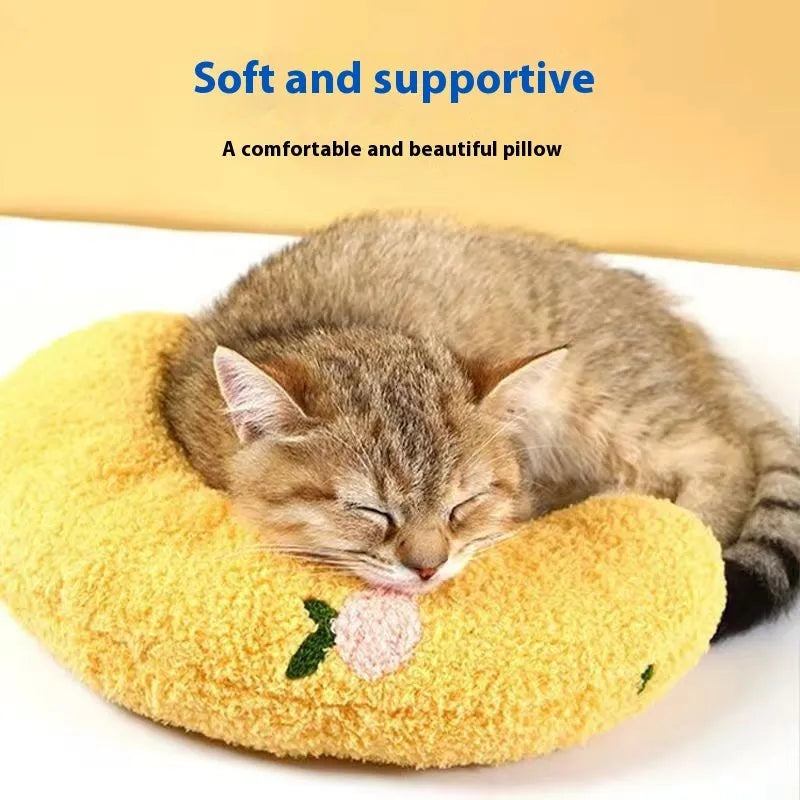 Blue and yellow question mark shaped cat bed with a U-shaped pillow for neck support on a wooden floor.