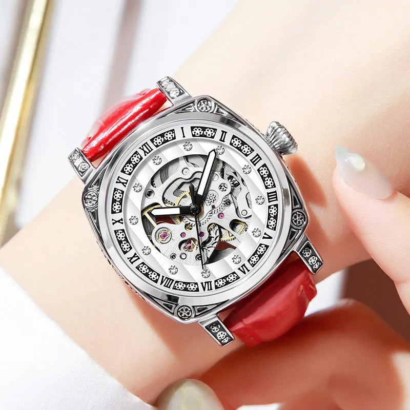Men's black leather strap mechanical watch with luminous hands on a wrist.