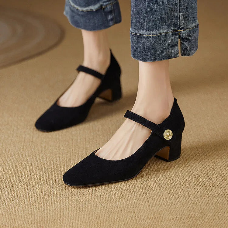 Women's black suede Mary Jane pumps with a chunky heel and square toe on a white background.