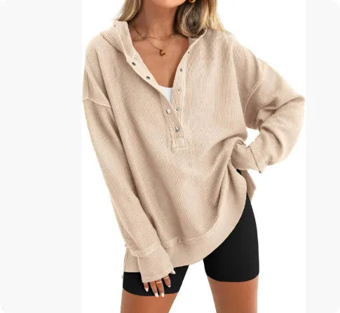 A woman wearing a loose peacock green pullover sweater with raglan sleeves.