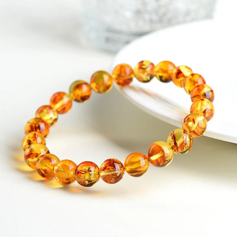 A geometric-bead amber bracelet with natural yellow piebald colouration on a wrist.
