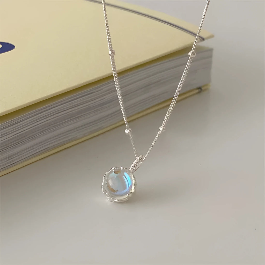 Women's silver necklace with a geometric stone pendant on a curb chain.