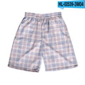 Man wearing straight-leg plaid shorts with an elastic waistband on a beach, showing one of twenty available colour variations.