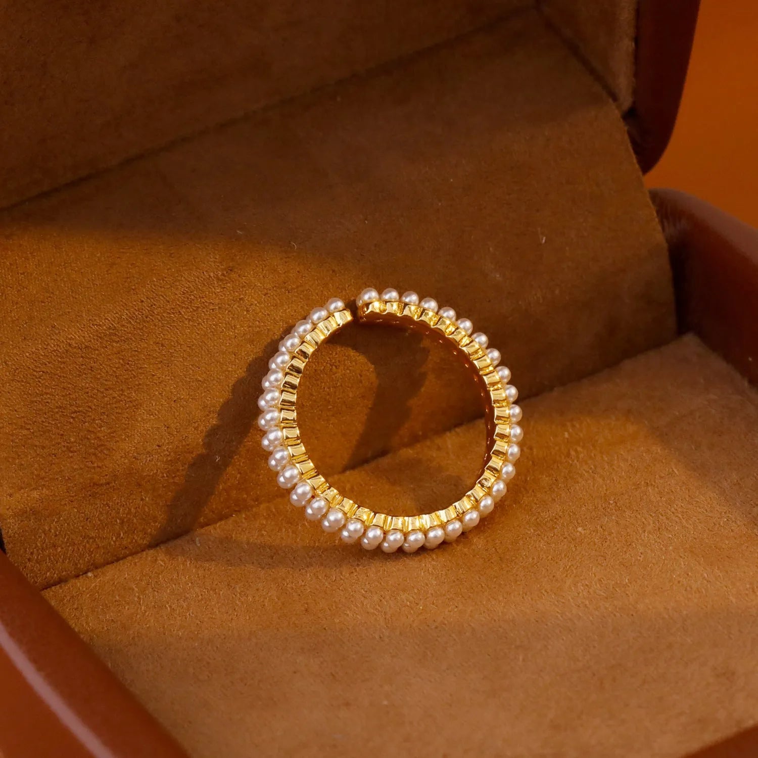 Gold electroplated pearl ring with open mouth geometric design on female hand