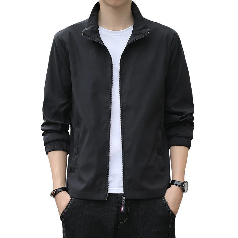 Man wearing a loose-fit black casual autumn jacket with a lapel and zippered pockets.