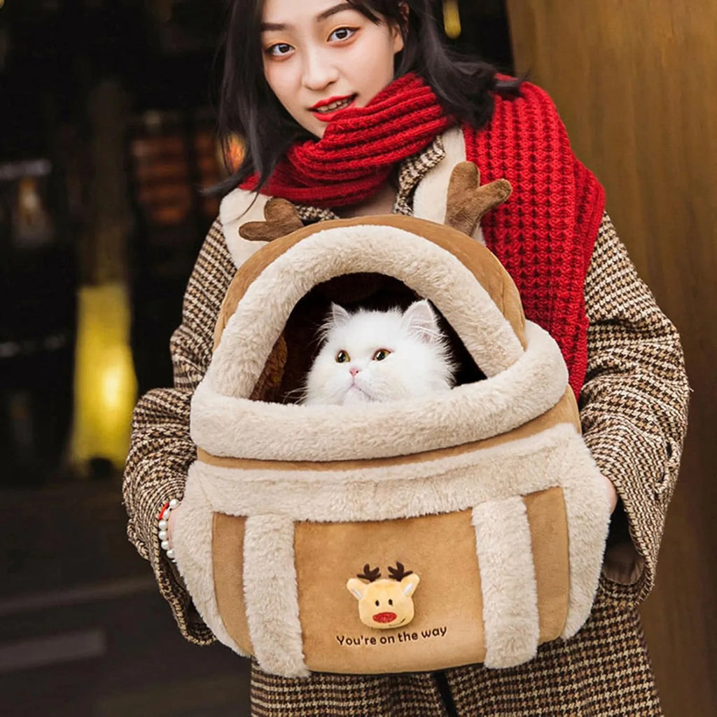 Plush reindeer pet carrier backpack with hand warmers in medium size for winter dog travel