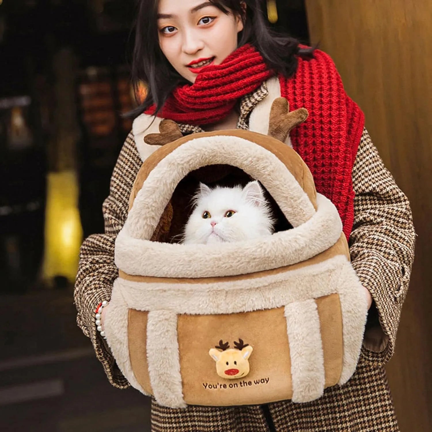 Plush reindeer pet carrier backpack with hand warmers in medium size for winter dog travel