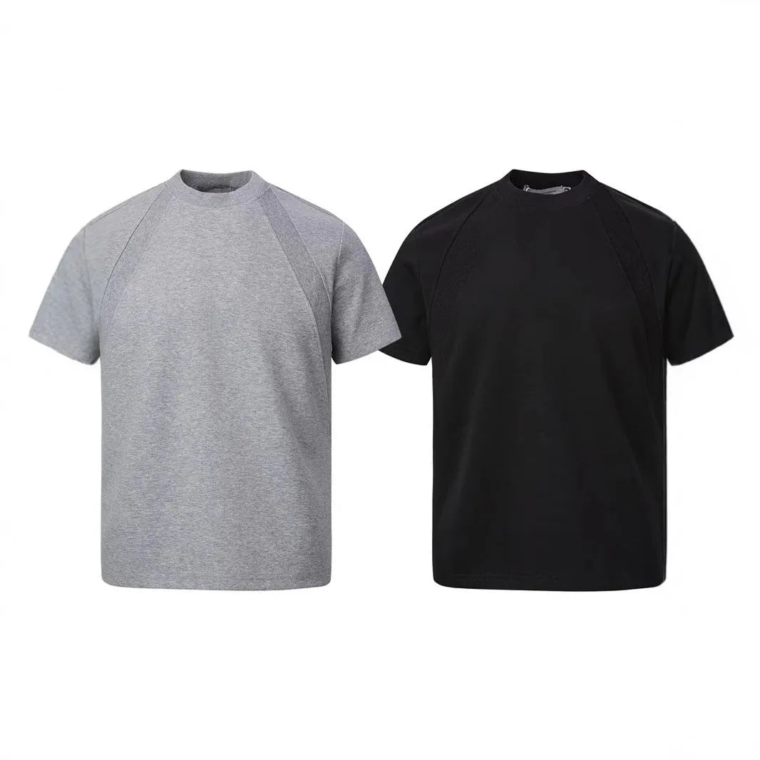 Men's loose fit short sleeve top in black with air layer stitching detail on a grey background.
