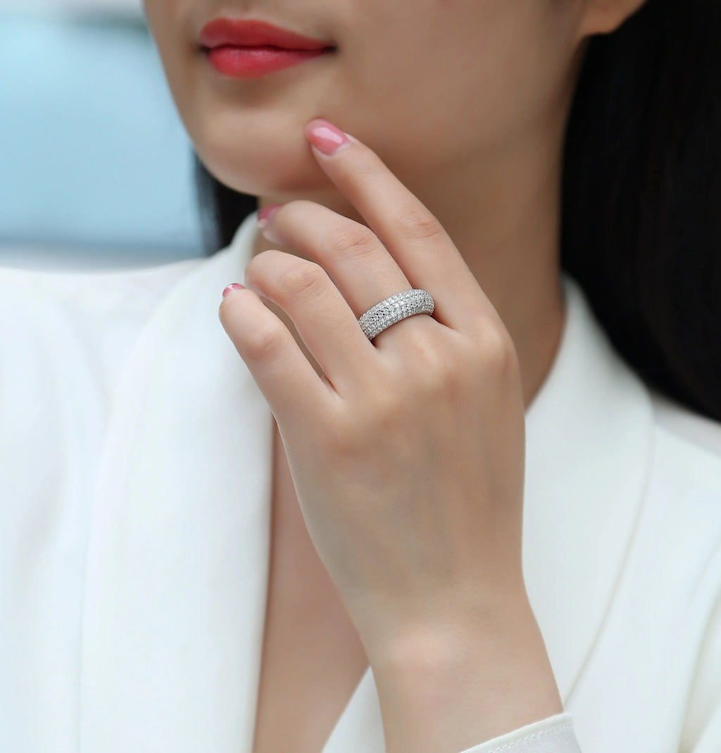 Moissanite wedding ring with S925 silver platinum plated band on flat surface showing stone and certificate