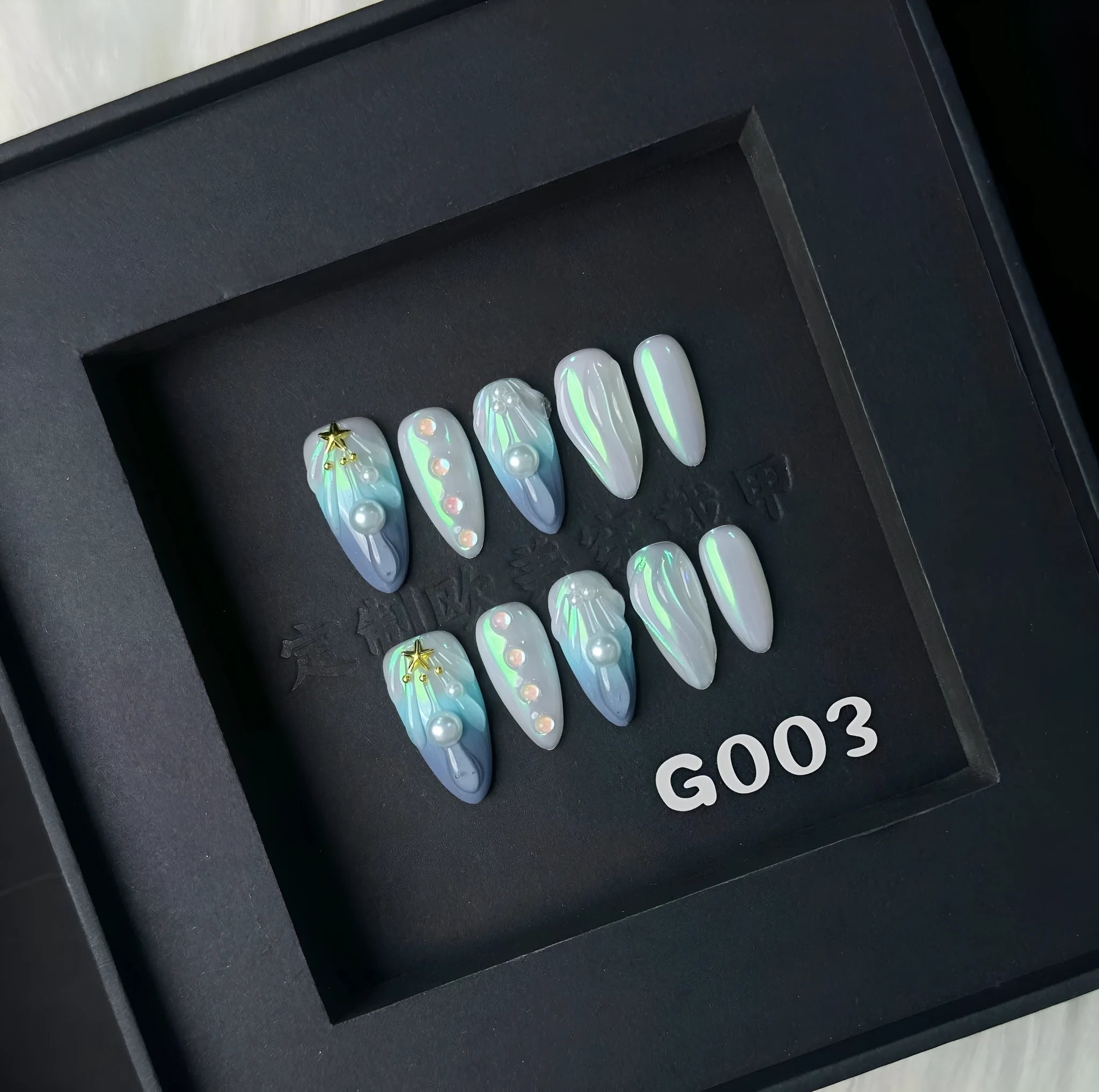 Set of blue plastic shell-shaped nail stickers in sizes XS, S, M, and L