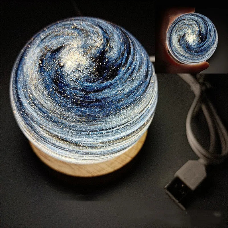 Modern planet-shaped USB night light with dimming on a desk.