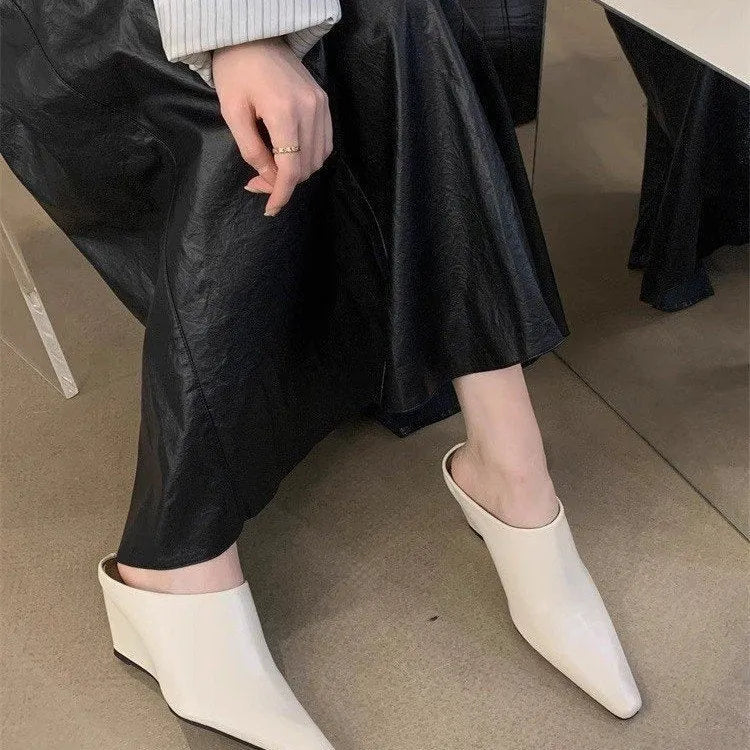 Women's black Wind Wedge closed toe half slippers with PU upper on a wooden floor.