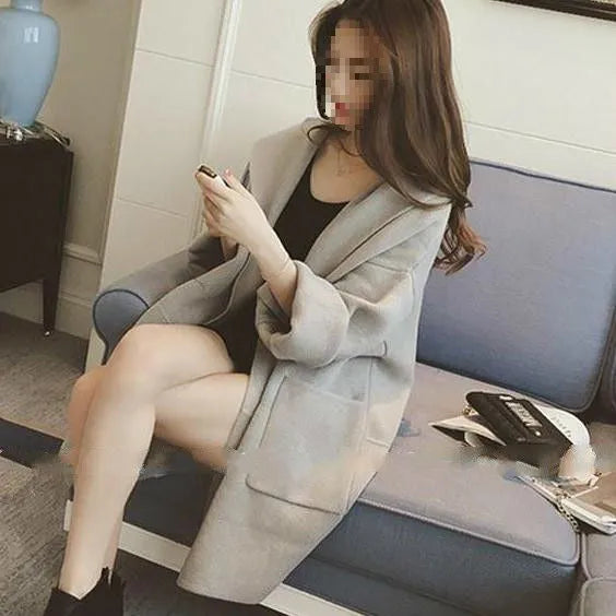 Plus size woman wearing a grey loose-fit cotton coat with lace detailing and long sleeves.