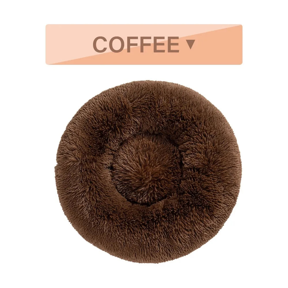 Fluffy grey donut-shaped dog bed with high plush sides on a wooden floor.