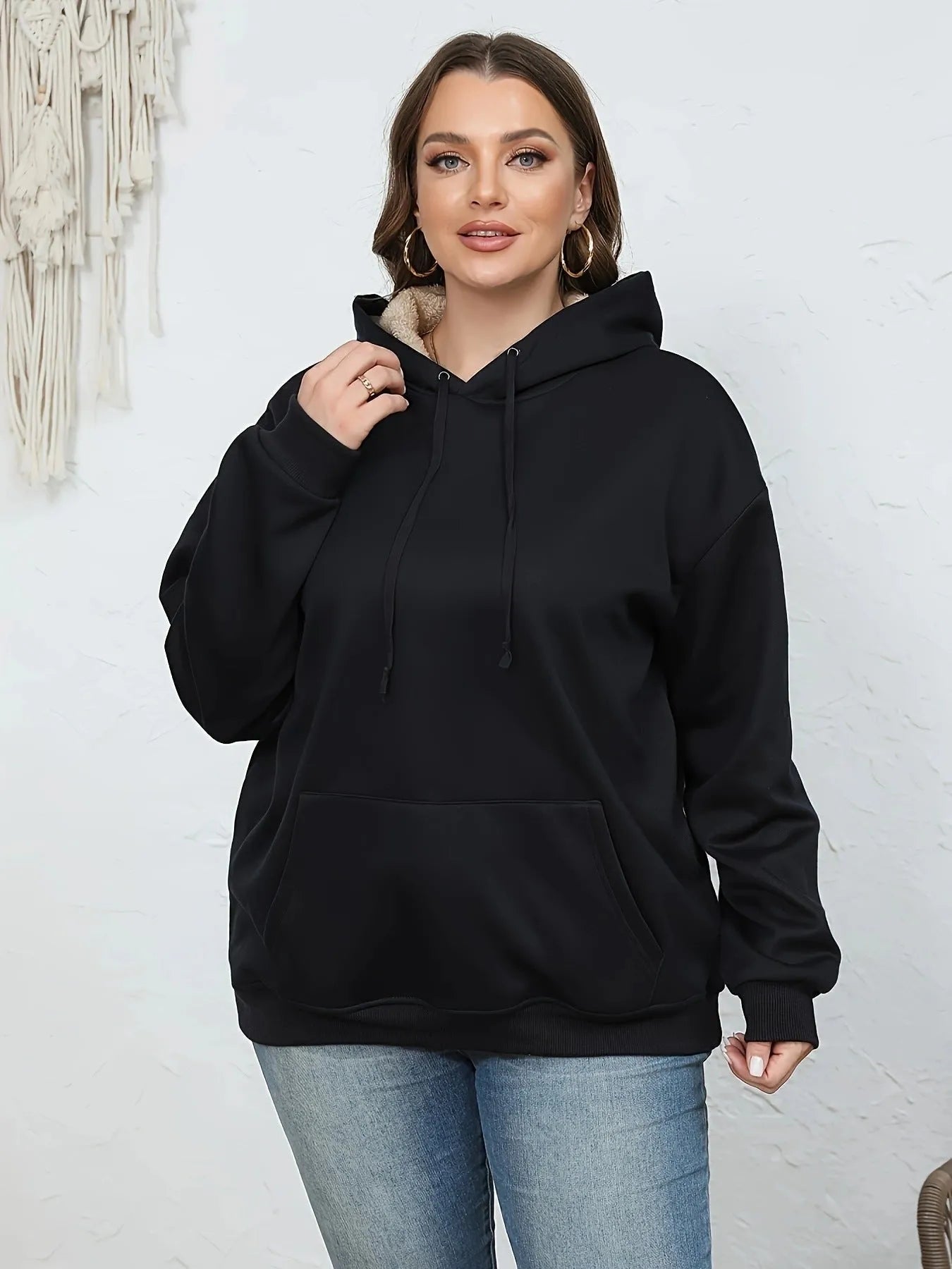 Women's loose hooded sweater with pockets in black colour showing 3D pattern detail