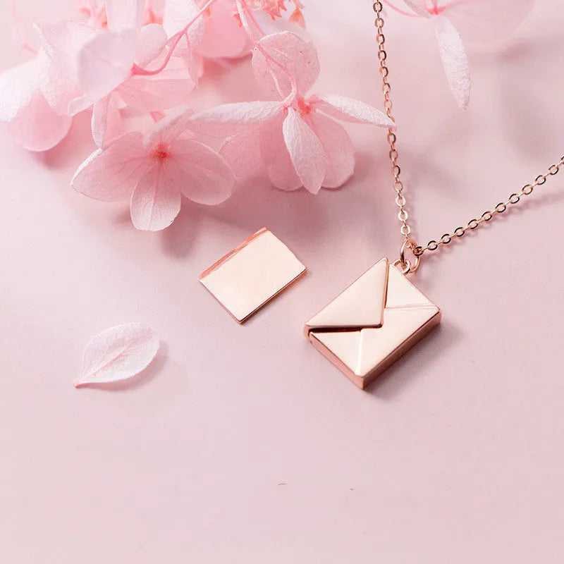Titanium steel envelope pendant necklace with chain on a woman's neck, gold finish