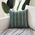 Square striped velvet pillow cover for sofa in multiple colour options on a grey background.