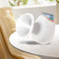 White and purple household eye humidifier with charging cable on wooden table