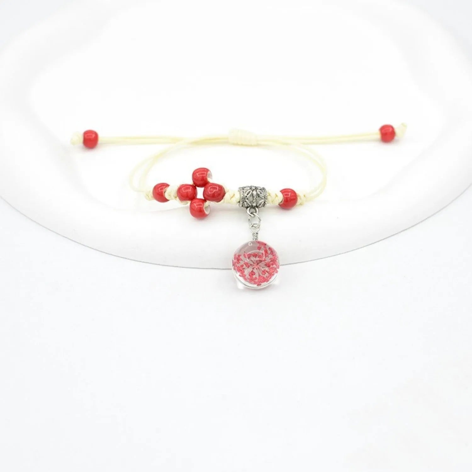 Hand-woven glass bracelet with large beads containing real dried flowers, shown in multiple colour options.