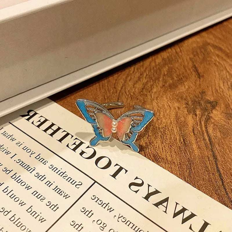 Creative butterfly design women's ring in copper with oil drip finish, showing an open loop style.