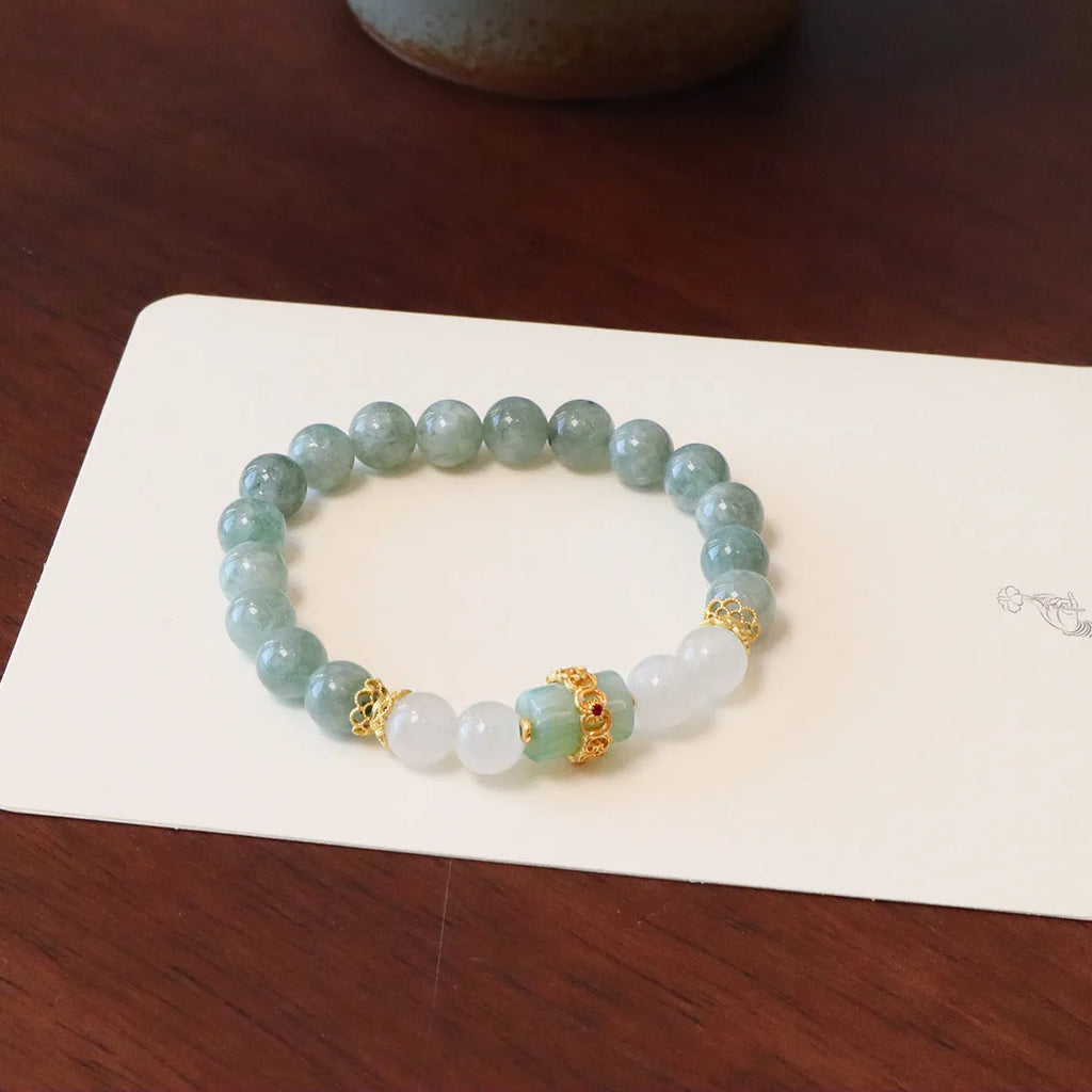 Women's bracelet with a silver peace buckle pendant and green Myanmar jade beads on a black cord.