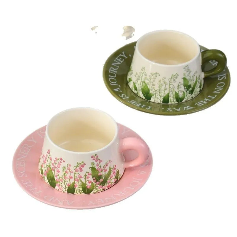 Ceramic coffee cup and saucer set for two with stirring spoons in couple's cup design.
