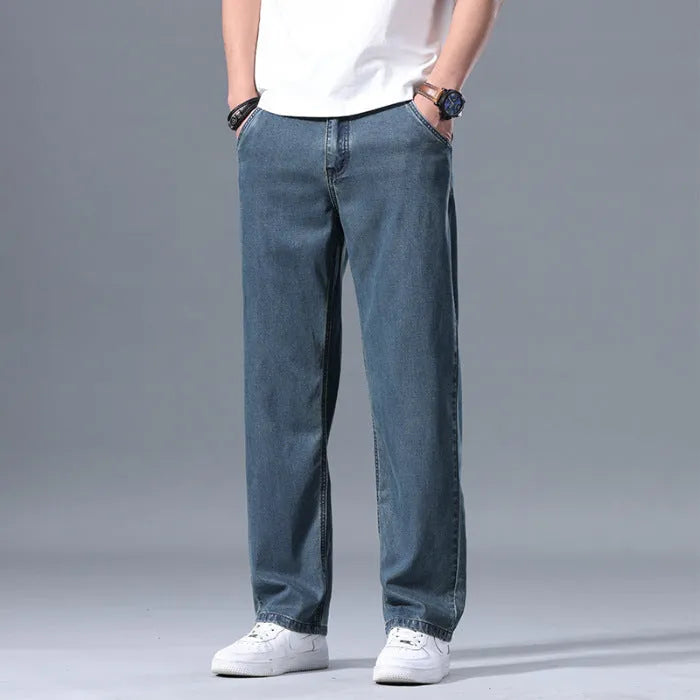 Man wearing light blue loose-fit straight-leg lyocell jeans with a zip fly